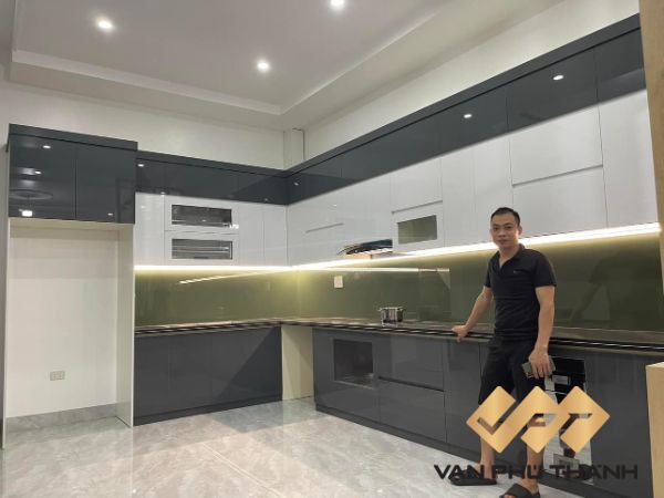Khách hàng của Vạn Phú Thành chụp cùng mẫu tủ bếp khung nhôm cánh Acrylic lắp đặt hoàn thiện